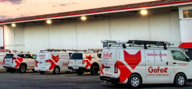 Electrical and Plumbing Franchise fleet showing multiple GoFox branded service vehicles lined up outside a depot, representing franchise operations.