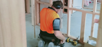 Electrical Services being carried out by a GoFox electrician installing wiring inside a framed wall during a residential build.