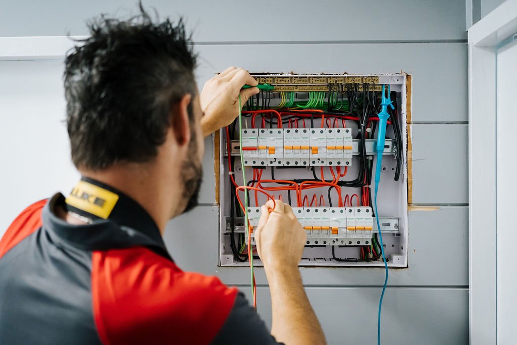 Registered Electrician carrying out detailed wiring and testing inside a residential electrical switchboard for safe, compliant installation.