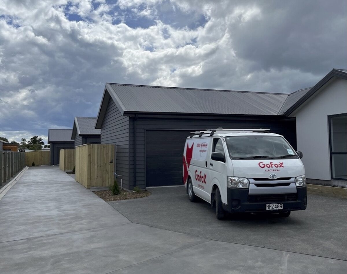 Landlord Electrical Safety Compliance supported by a GoFox Electrical service van parked outside newly built rental townhouses.