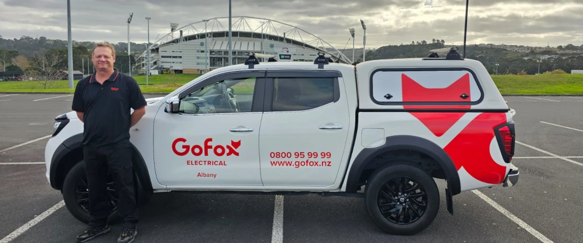 Local Electrician in Albany standing beside GoFox Electrical service vehicle outside North Harbour Stadium in North Auckland