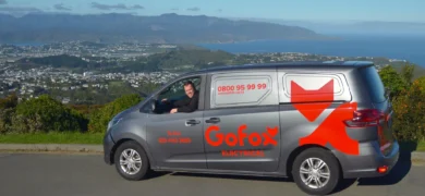 Local Electrician Wellington GoFox Electrical Te Aro van parked at scenic lookout overlooking Wellington city and harbour with technician inside vehicle