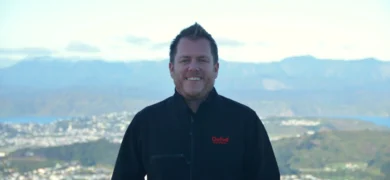 GoFox Electrical owner Dan McLaughlan standing at a scenic Wellington lookout with city and harbour in the background