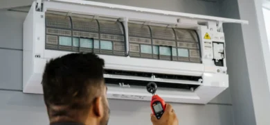 Heat Pump Installation and Servicing carried out by a GoFox electrician testing airflow on an open wall-mounted heat pump unit during maintenance.