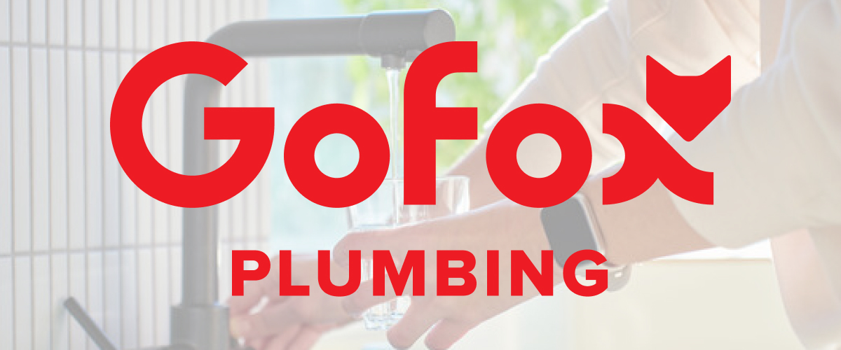 Water filter installation by GoFox Plumbing, showing a person filling a glass from a modern kitchen tap with a filtration system fitted below.