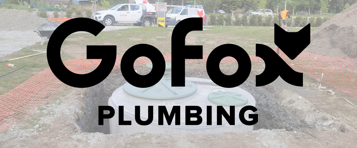 Plastic vs Concrete Septic Tanks: a round concrete septic tank installed in an excavated site, with GoFox Plumbing vehicles and safety fencing in the background.