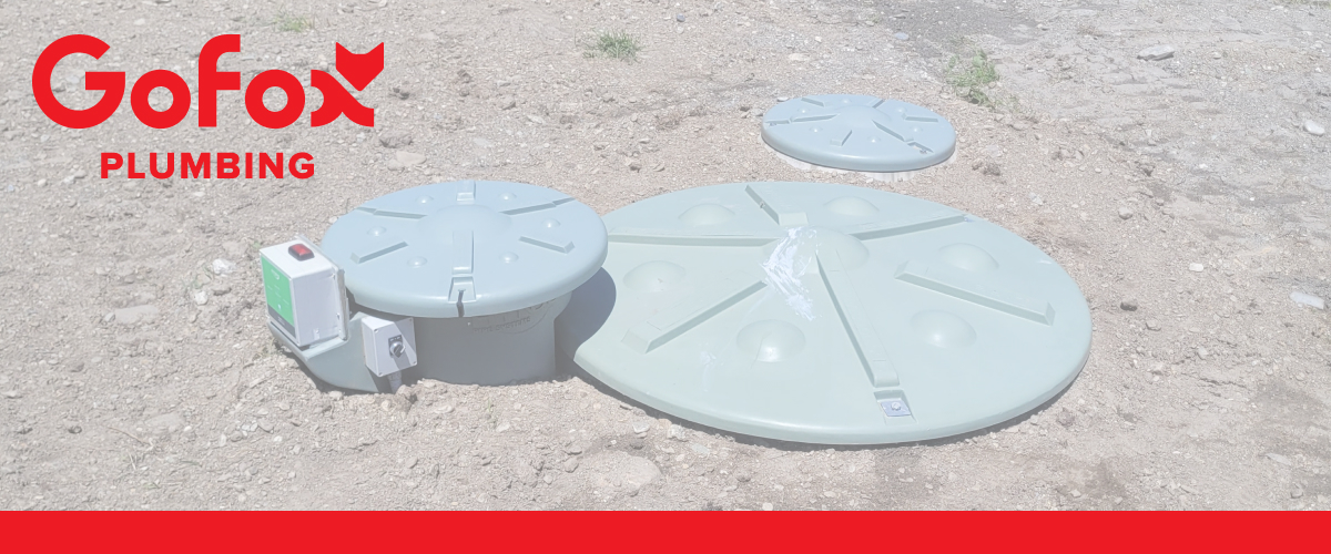 Septic Tank Size comparison: three different sized wastewater tank lids installed in the ground, with a control panel and alarm unit beside the smallest tank.